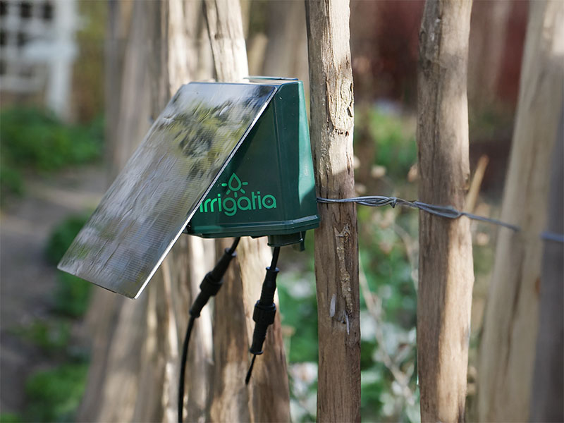 Irrigatia enhet på staket mot köksträdgård