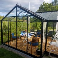 Växthus orangeri Helene inrett med matbord och soffgrupp