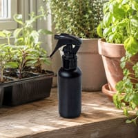 Sprayflaska för bladnäring bland krukor